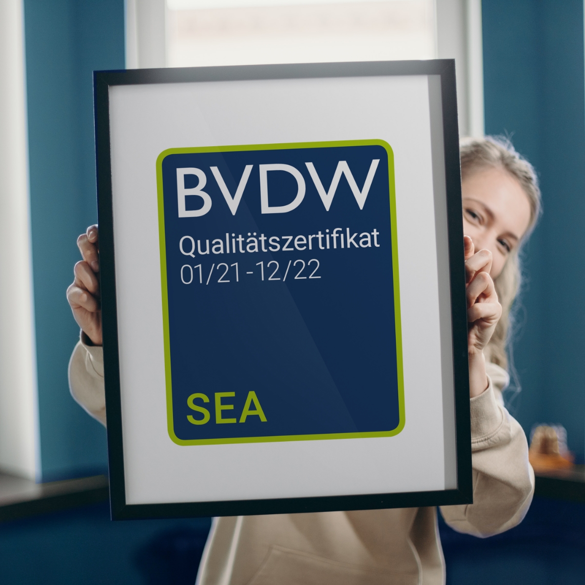 Foto - Frau hält Bilderrahmen mit BVDW Qualitätszertifikat SEA